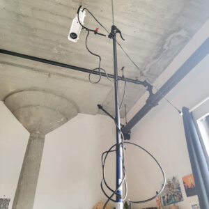Projector on a tension pole facing down towards a sewing table